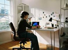 Man at desk on phone with laptop